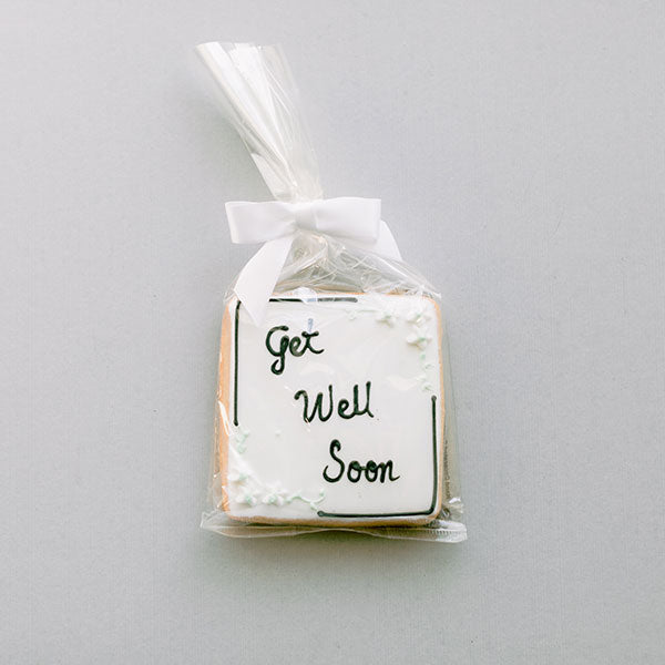 Square sugar cookie iced white with Get Well Soon, wrapped in cellophane with a white bow
