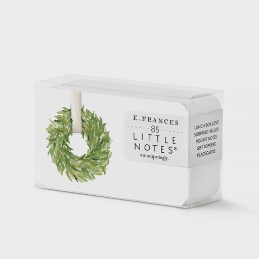 Watercolor illustration by E. Frances Paper of 85 Little Notes stationery cards in a clear box featuring a lush green leafy wreath with a white ribbon and crisp black typography