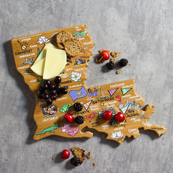 Bamboo charcuterie board by Fish Kiss featuring a colorful map of Louisiana with landmarks like the State Capitol and vibrant illustrations of a green alligator and red crawfish topped with cheese and fresh berries