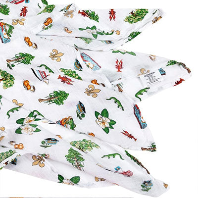 Illustrated muslin fabric featuring iconic New Orleans landmarks including the St. Louis Cathedral and a river steamboat alongside vibrant red crawfish, green alligators, and white magnolia blossoms