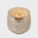 Studio photograph of a three-wick scented candle in a textured champagne mercury glass jar on a neutral background featuring three flickering orange flames and a shimmering metallic hobnail finish