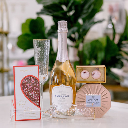 Rose themed Valentine's Day gift box, champagne and glasses with a Voluspa candle and cocktail bombs gift basket