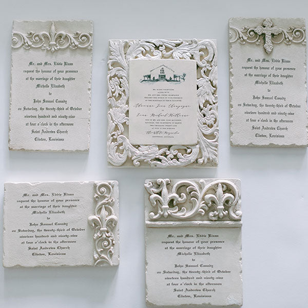 A collection of wedding invitation plaques in various designs, featuring intricate borders and decorative elements.