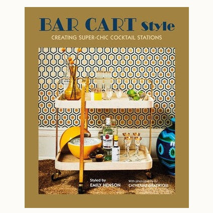 Book cover photography by Catherine Gratwicke and styling by Emily Henson showcasing a two-tier bar cart against hexagonal wallpaper with the title BAR CART Style, a yellow spherical ice bucket, and a large blue patterned floor vase