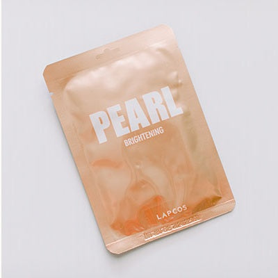 Digital product photography of a Lapcos Pearl Brightening sheet mask featuring a metallic rose gold pouch with bold white typography and a hanging tab on a neutral studio background