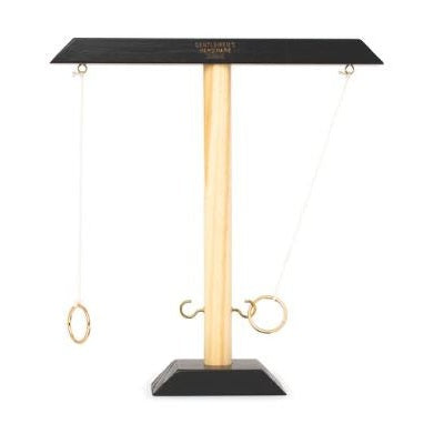 Tabletop ring swing game with a black top bar and base, wooden post, gold rings on strings and a hook